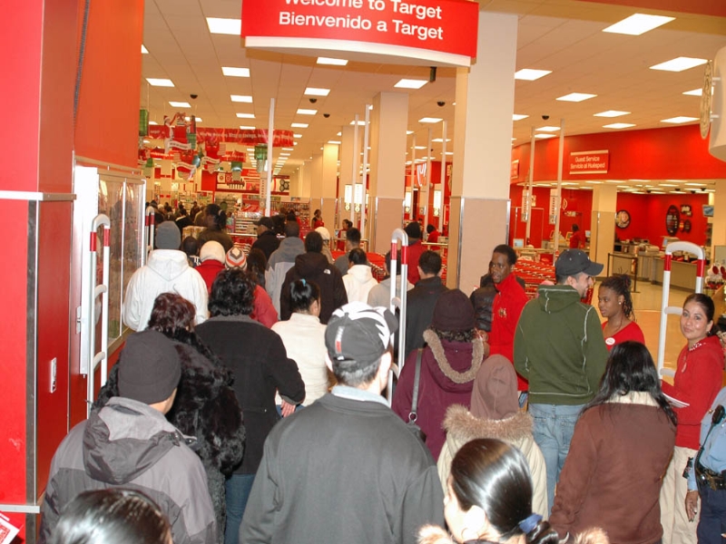 This is a picture of a Target store opening its doors on Black Friday. Many shoppers are marching in the store at once.