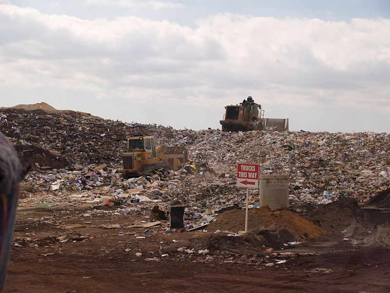 This is a picture of a landfill in Australia. It's basically a big pile of garbage with a large steamroller or compactor or something driving through it.