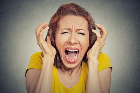 This is a photo of a young woman who is screaming. She appears very distressed.